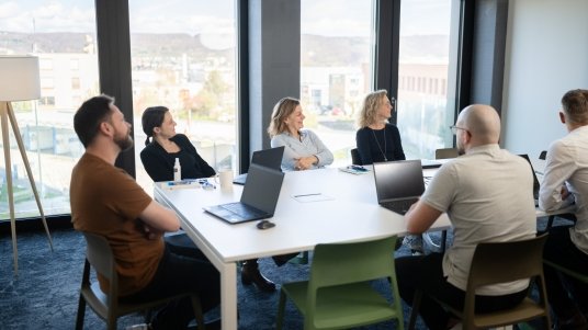 Mehrere Personen in einem modernen Meetingraum bei einem Workshop zur Prozessautomatisierung