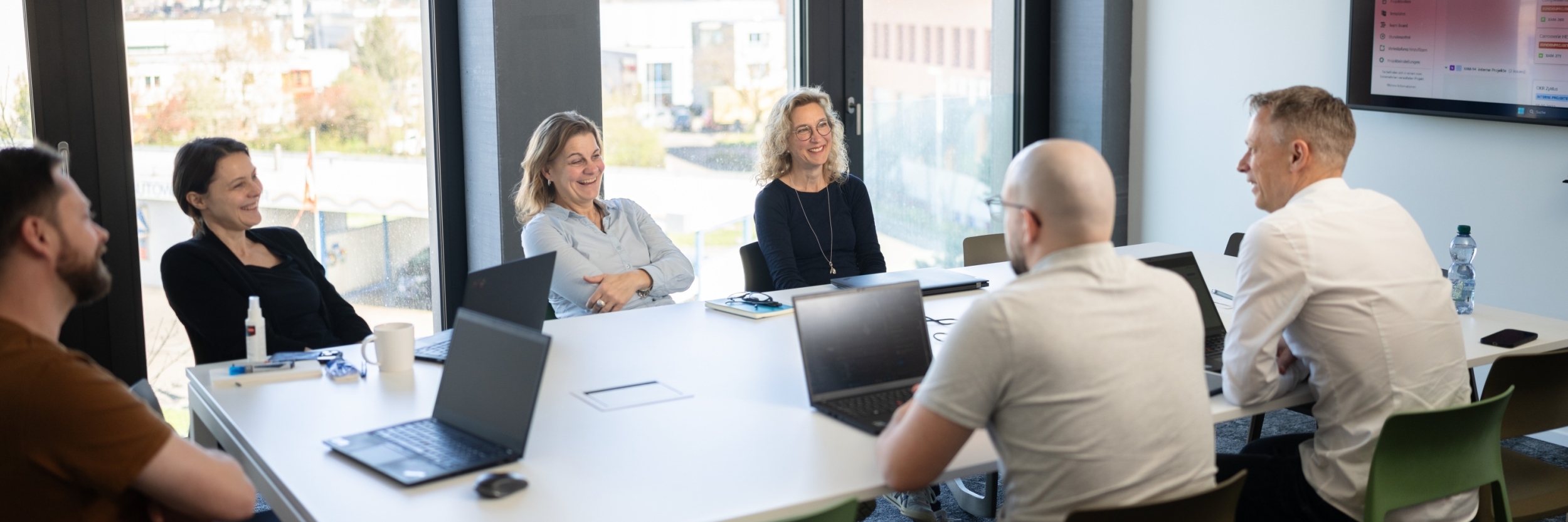 Teammeeting im modernen Besprechungsraum – gemeinsames Arbeiten an kundenorientierten Lösungen