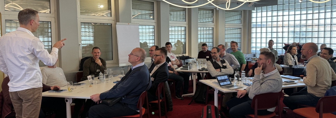 Teilnehmende des Matrix42-Gruppentreffens im aktiven Austausch – Vortrag und Diskussion in moderner Workshop-Atmosphäre