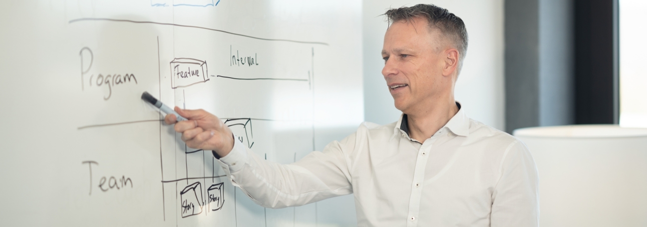 Mitarbeiter erklärt ein USM-Konzept am Whiteboard – strukturierte Serviceprozesse im Foku
